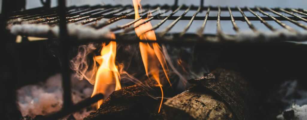 Na zdjęciu widoczny grill podczas rozpalania drewnem